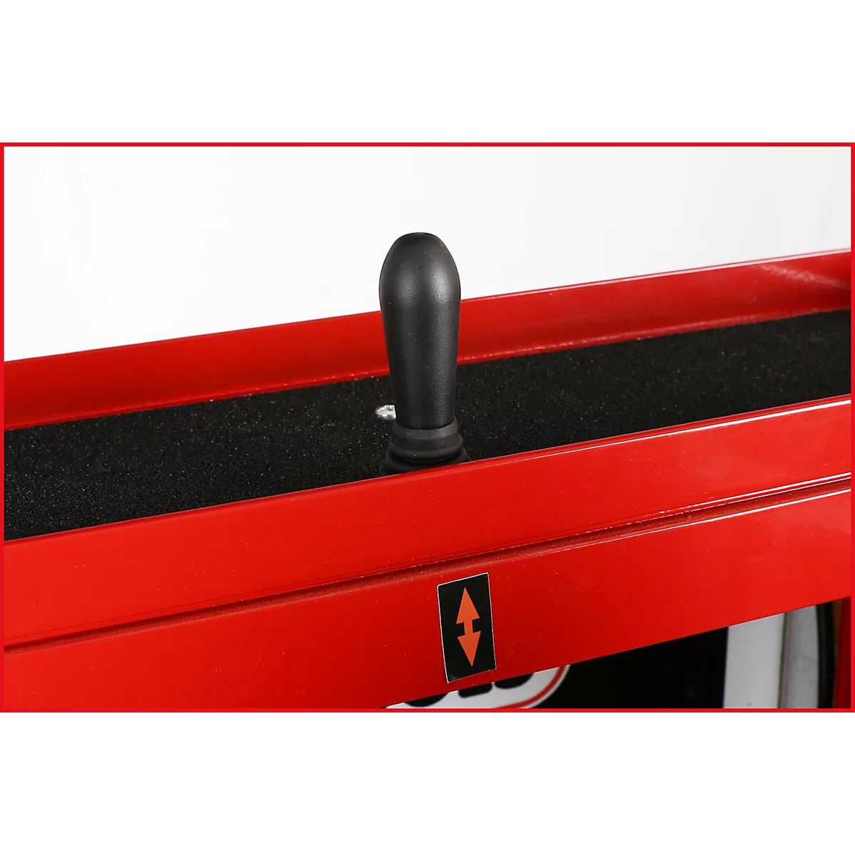 Detailaufnahme eines rot lackierten Metallrahmens mit einem schwarzen Hebel. Der Hebel steht auf einem schwarzen Schaumstoffstreifen.